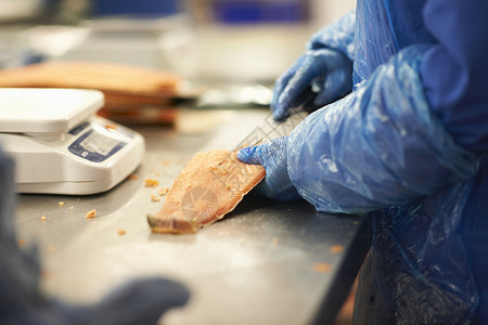 工厂里切割鱼肉的工人高清图片