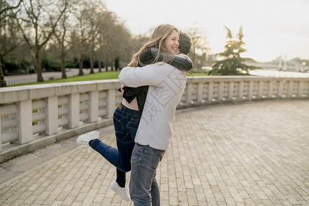 在英国伦敦Battersea公园拥抱女友的浪漫青年男子，爱情，美好，异性伴侣高清图片素材