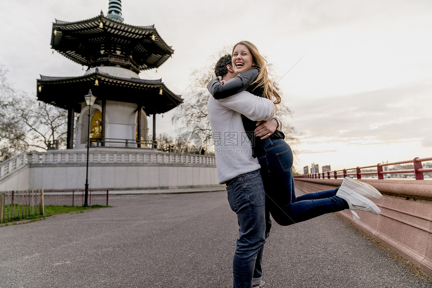 快乐的年轻人拥抱女友，英国伦敦巴特西公园，爱情，图片