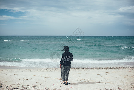 意大利萨萨里索索海滩上看大海的女人的后视图高清图片