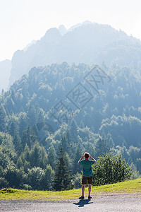 意大利帕索马尼瓦一名男子仰望树木覆盖的群山图片