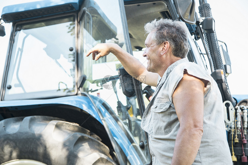 手扶拖拉机的成熟男性农业工人图片