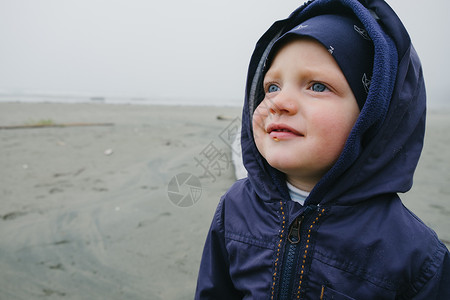 觉华岛在加拿大不列颠哥伦比亚省温华岛长滩海上站立的年轻男孩在微笑背景