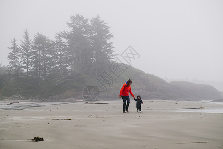 觉华岛母亲和儿子在加拿大不列颠哥伦比亚省温华岛长海滩上散步背景