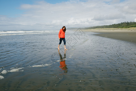 觉华岛加拿大不列颠哥伦比亚省温华岛长海滩赤脚步行的年轻妇女背景