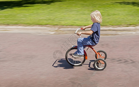 男孩骑三轮车高清图片
