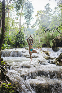 瀑布中做瑜伽的女性高清图片