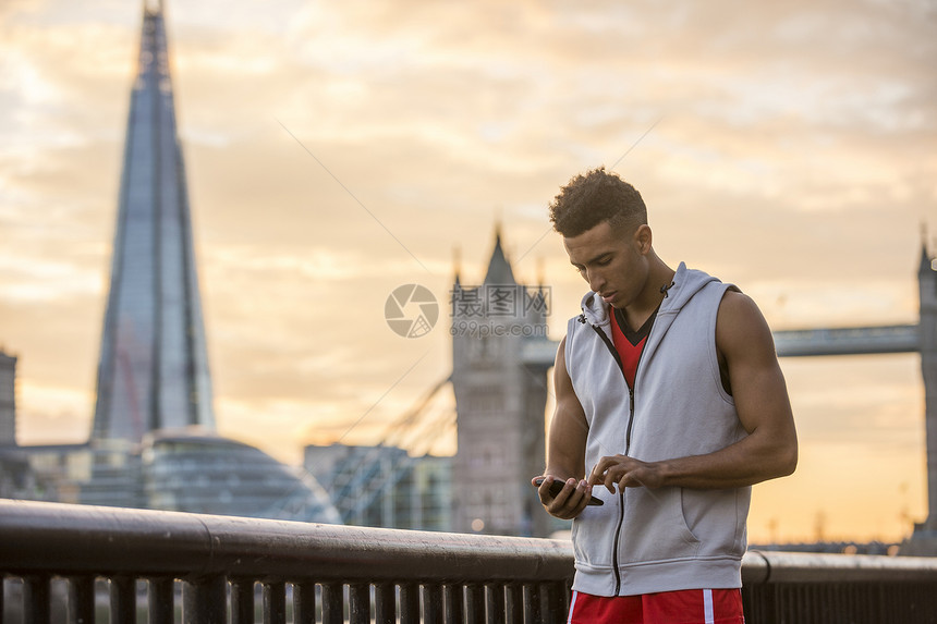男子使用移动电话沿河边塔桥和沙原使用移动电话背景情况联合王国伦敦Wapping图片