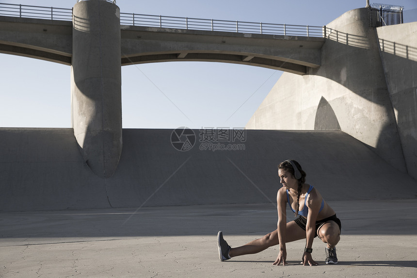 美国加利福尼亚VanNuysVanNuys带耳机伸展的女运动员图片
