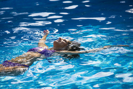 女人在游泳池仰泳图片