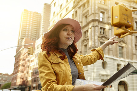 美国纽约曼哈顿街上问路的红色头发的女游客休闲服高清图片素材