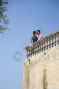 在屋顶阳台上接吻的情侣背景图片