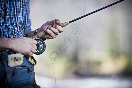 男人握着钓鱼竿背景图片