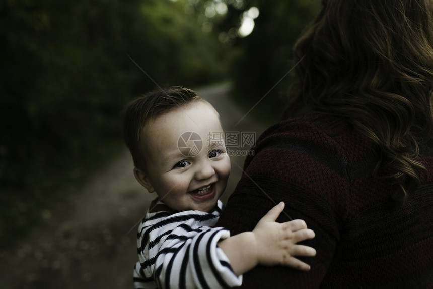 婴儿在母亲的怀中看着镜头微笑图片