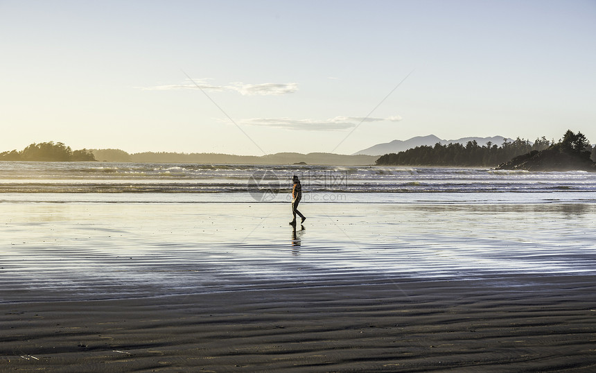 日出时海滩上散步的男人加拿大环太平洋公园图片