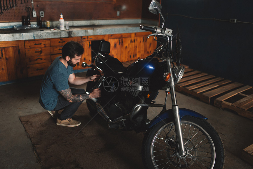 在车间修理自行车的男子图片