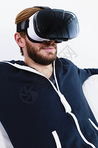 在沙发上看VR眼镜的中年男子图片