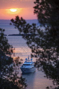 日落时停靠在西班牙马雅卡尔维亚海岸的游艇高清图片