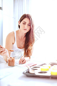 使用勺子的女性从罐里吃太妃糖图片