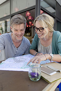 咖啡厅桌上看地图路线的夫妇图片