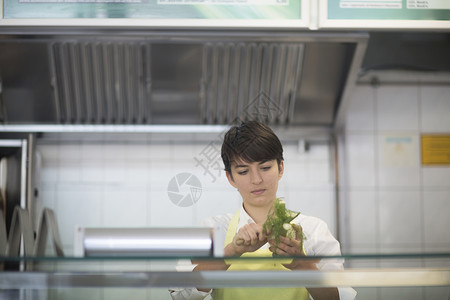 在快餐店做饭的年轻妇女图片