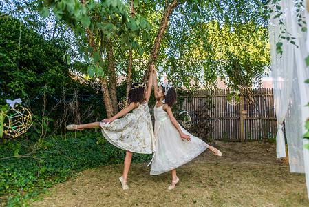 两个年轻女孩打扮成仙女在户外跳舞梦幻般的高清图片素材