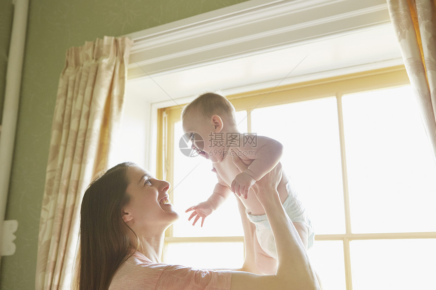 妇女把婴抱起图片