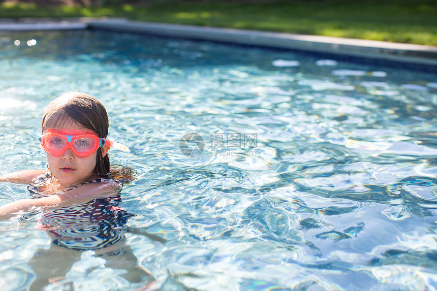 在户外游泳池中穿粉红色游泳护目镜的女孩肖像图片