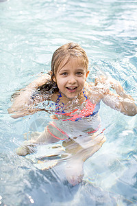 在户外游泳池打水的女孩肖像踩水高清图片素材