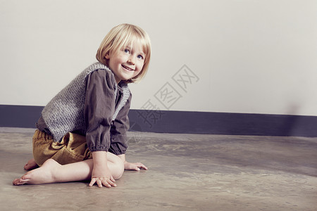 顽皮的女孩跪坐在地板上图片