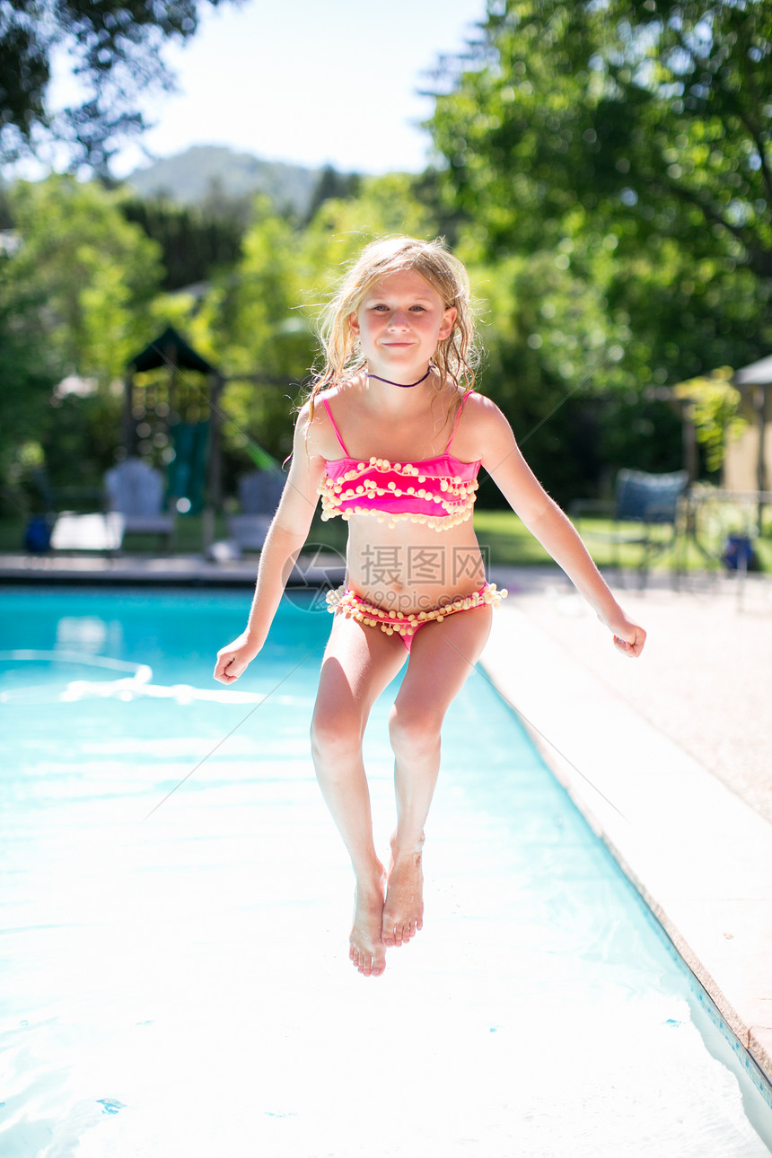 女孩跳入户外游泳池的肖像图片
