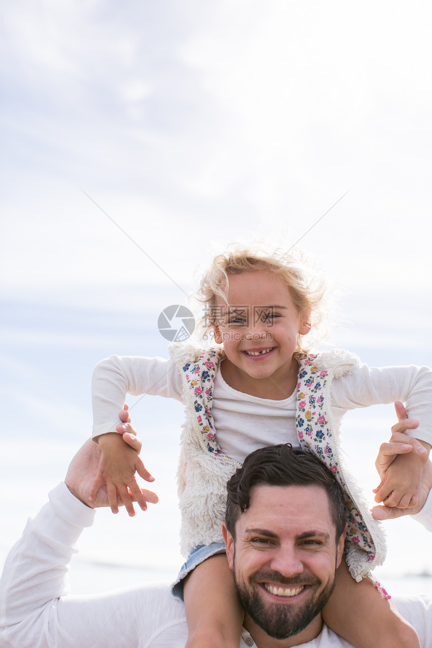 成熟男人的肖像给女儿一个肩膀背在海岸图片
