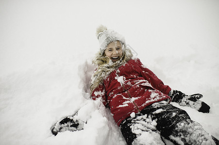 微笑的女孩躺在背上满身是雪图片