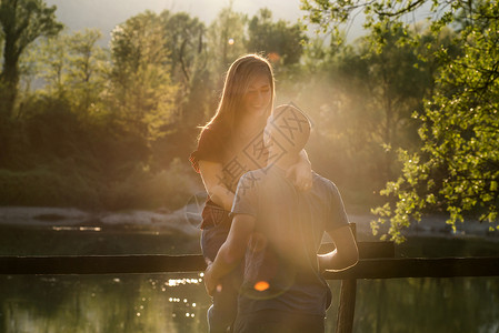 在河边拥抱的一对情侣年轻女子高清图片素材