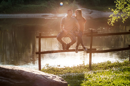 坐在河边的围栏上的情侣成年女子高清图片素材