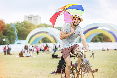 撑着雨伞骑自行车的男子图片