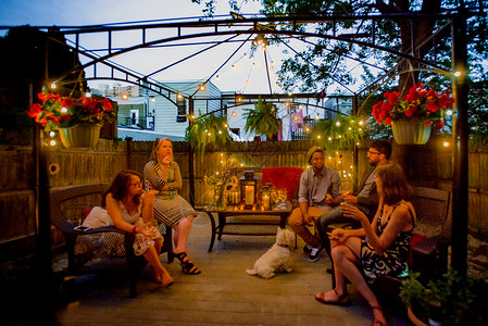 一群人在花园派对上坐在黄昏的贝戈拉下喝着葡萄酒成年高清图片素材