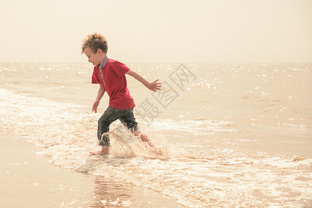 在海滩上奔跑玩耍的男孩图片