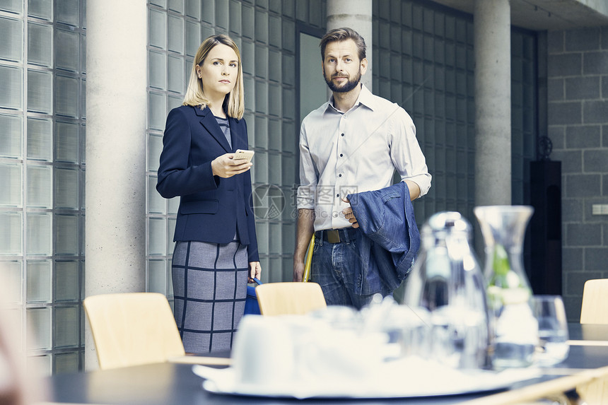 女商人和男站在会议室桌前图片
