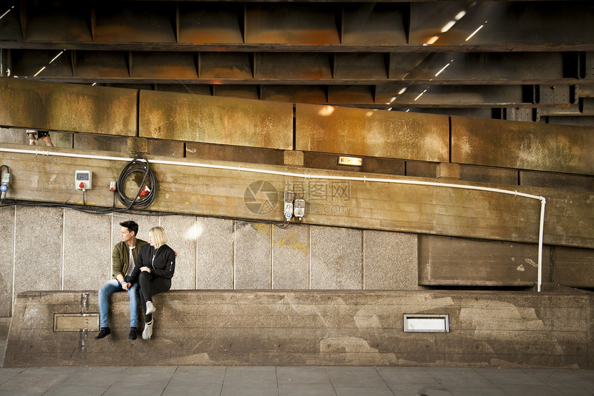 年轻夫妇坐在桥下放松图片