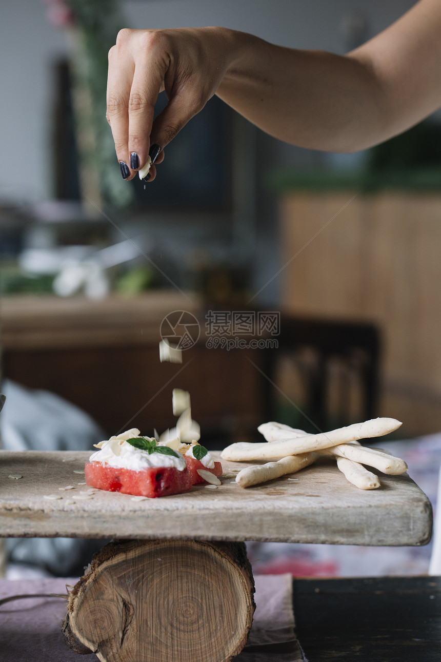 在切割板上制作素食菜盘子的妇女图片