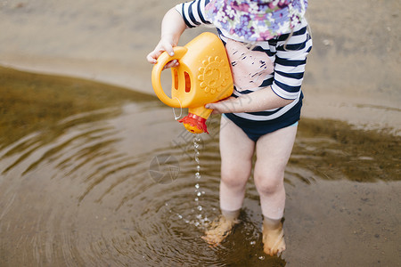 女孩脚踝深处的湖中倒水来自玩具罐汉斯维尔加拿大女的高清图片素材