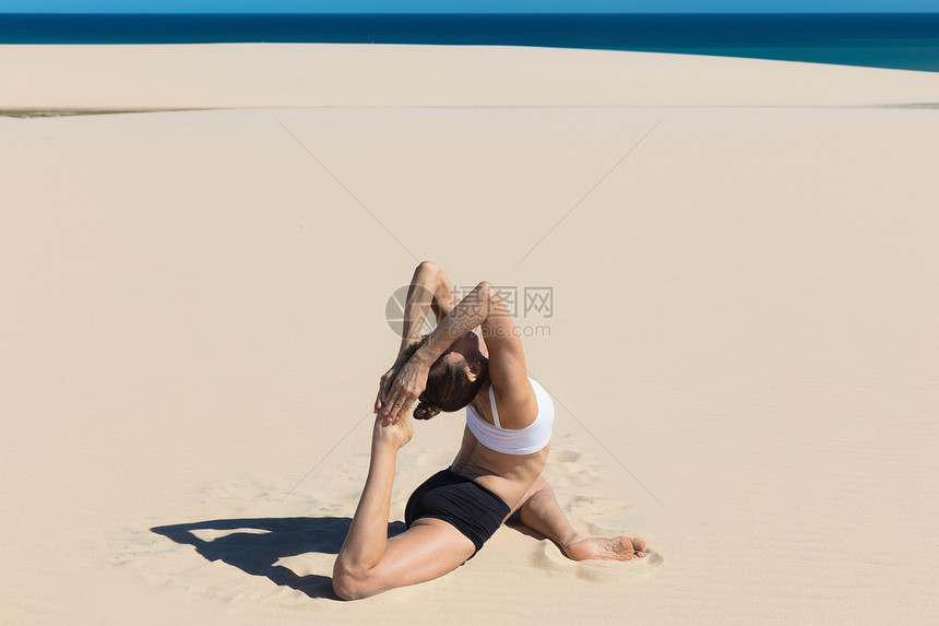 女人在沙滩上做瑜伽图片