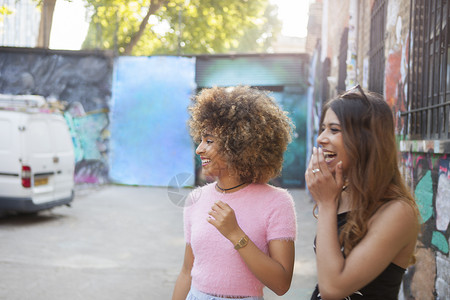 街上两个年轻女人望着远处笑图片