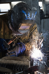 在车间焊接金属器的铁匠高清图片