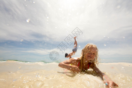 女孩躺在浅水海滩上哥在准备倒立站着假期高清图片素材