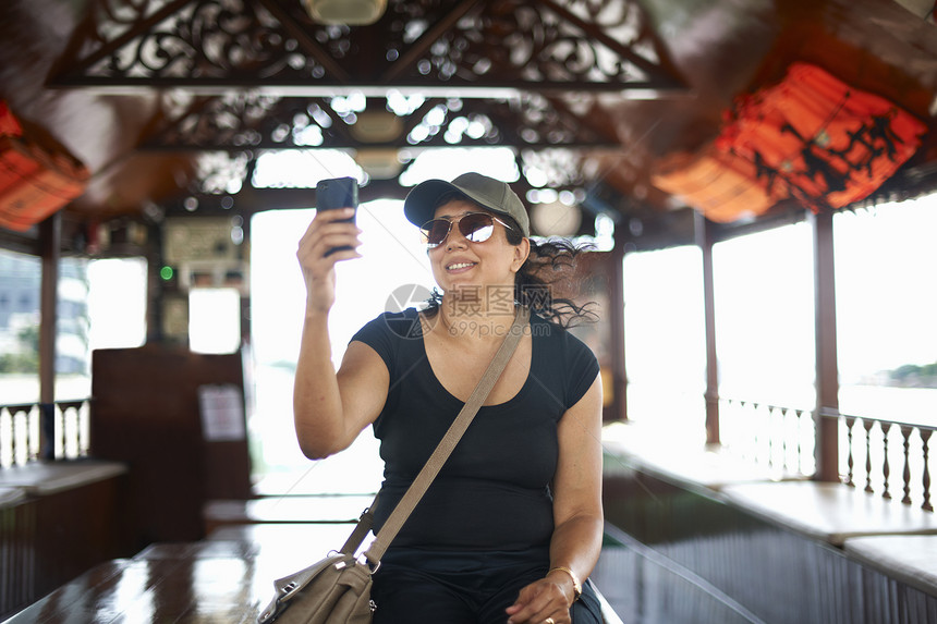 用手机微笑自拍的女人曼谷图片