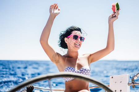 划西瓜船女孩穿比基尼的女人在船上高举双手背景