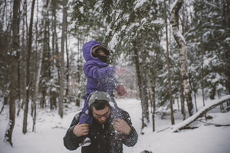 父亲和女儿身处雪地父亲肩上怀着女儿图片