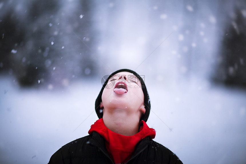 男孩的肖像在舌头上抓着落雪图片
